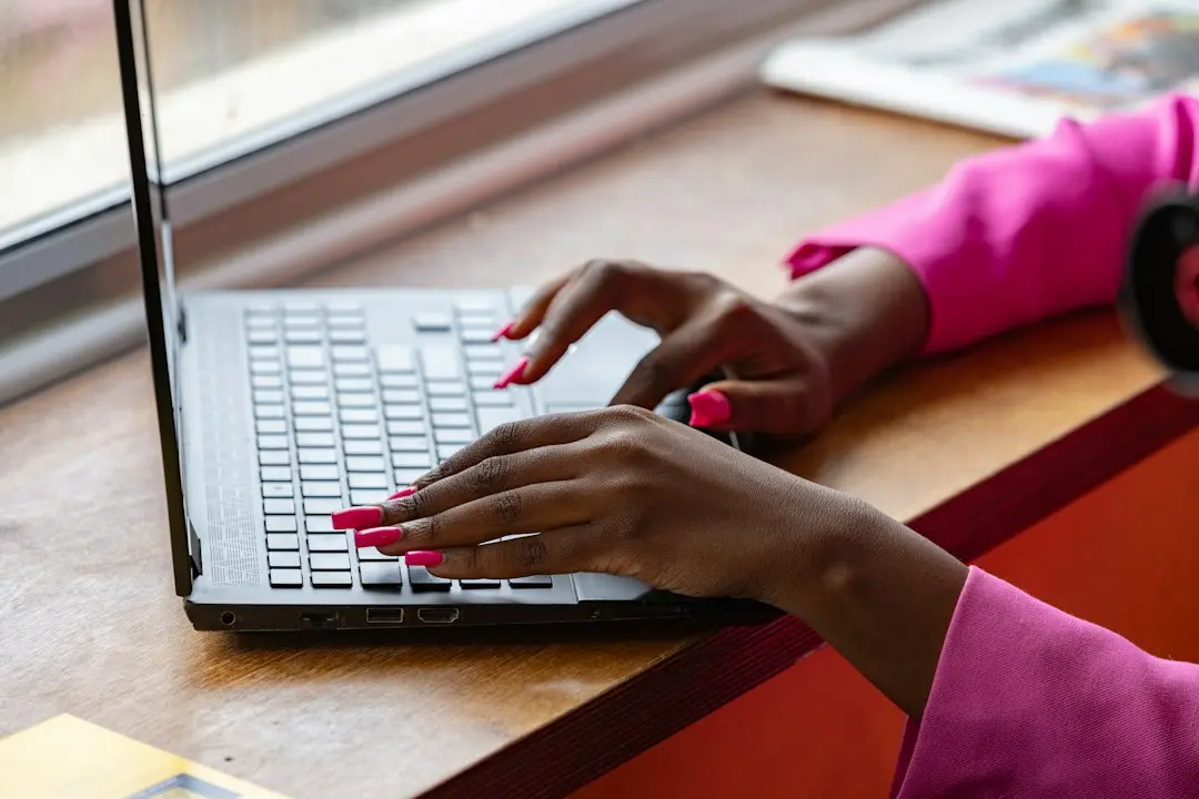 Hands typing on a laptop by a window, as when adding a MyrixTV M3U playlist to a player app