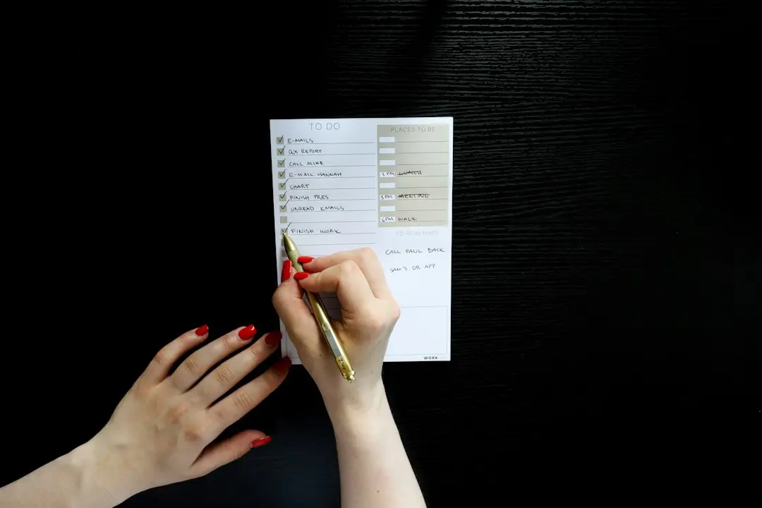 A hand ticking items on a to-do list, like a checklist for judging top rated IPTV lists and MyrixTV